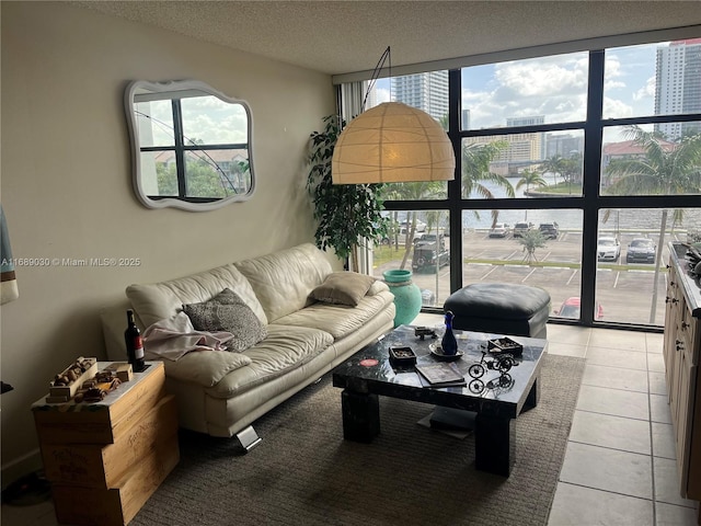 living room with light tile patterned floors, a wall of windows, and a textured ceiling