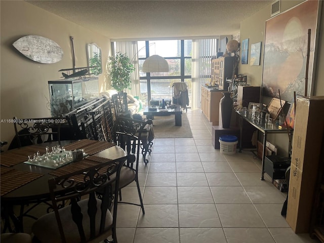 dining space featuring light tile patterned flooring, floor to ceiling windows, and a textured ceiling