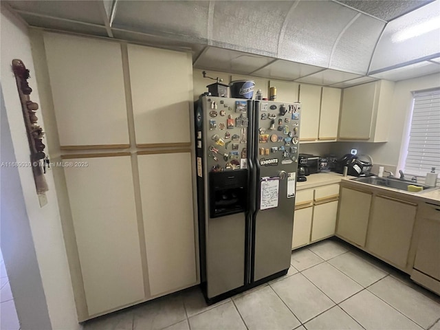 kitchen with light tile patterned flooring, sink, stainless steel fridge with ice dispenser, white dishwasher, and cream cabinetry