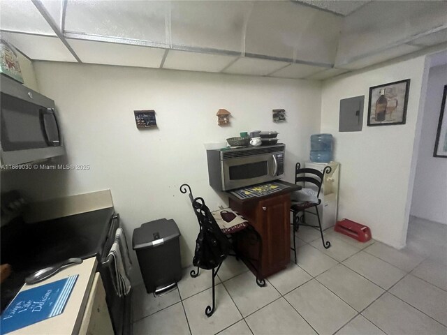 tiled home office with a paneled ceiling and electric panel