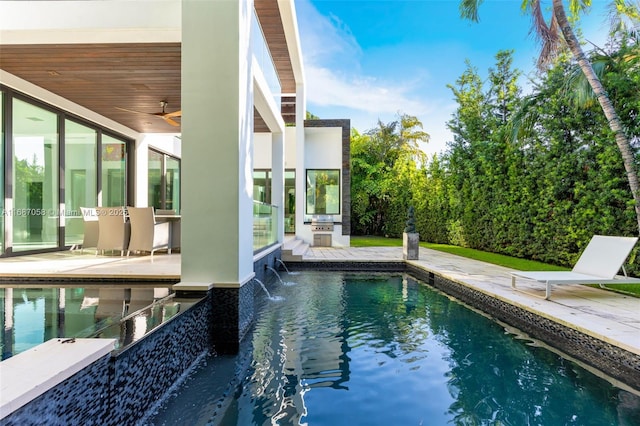 view of swimming pool featuring a patio, pool water feature, area for grilling, and ceiling fan