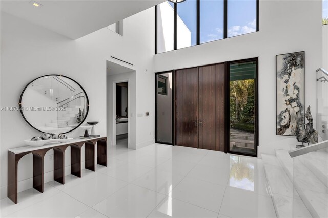 entryway with a high ceiling and light tile patterned floors