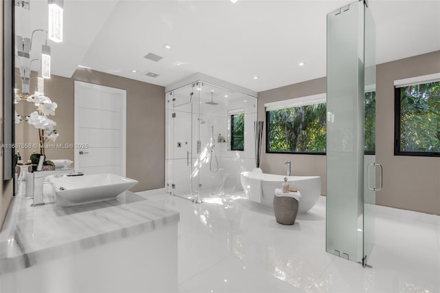 bathroom with a healthy amount of sunlight and shower with separate bathtub