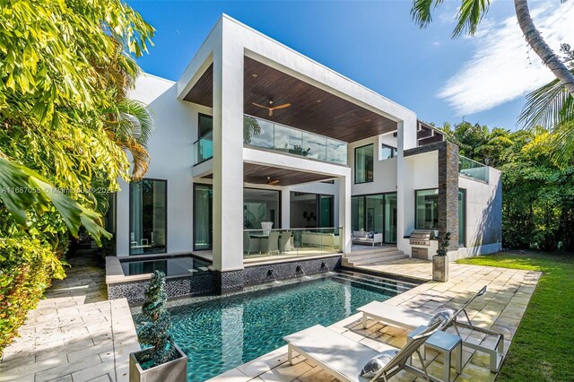 back of property with an outdoor kitchen, ceiling fan, a balcony, and a patio