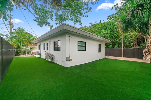 back of house with a lawn and central AC unit