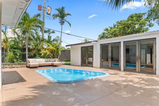 view of pool with a patio area, outdoor lounge area, and french doors