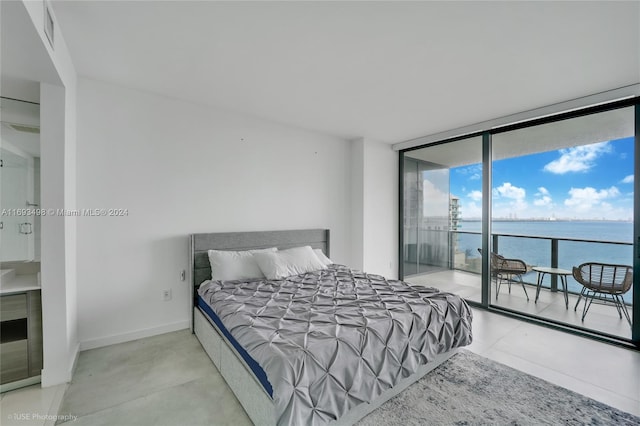 bedroom with access to exterior, a water view, and floor to ceiling windows