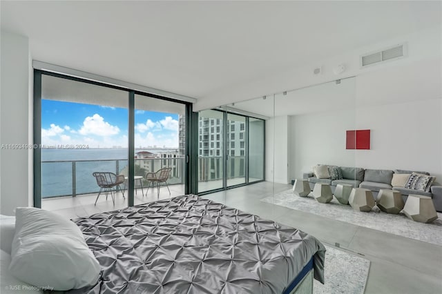 bedroom featuring floor to ceiling windows, a water view, concrete flooring, and access to outside