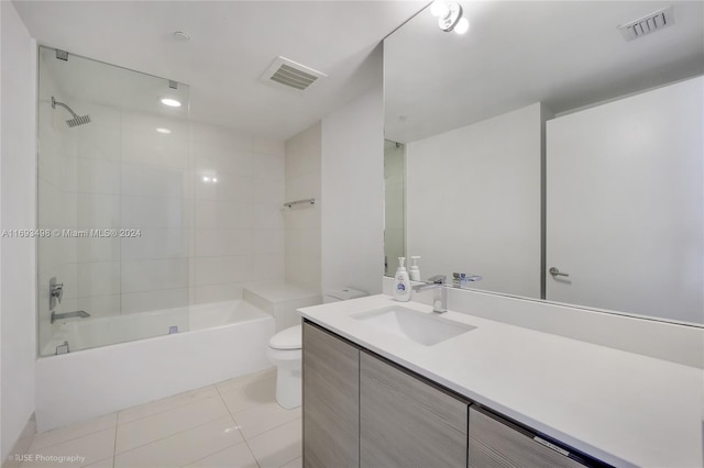 full bathroom featuring tile patterned flooring, vanity, tiled shower / bath combo, and toilet