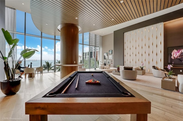 recreation room with wooden ceiling, expansive windows, hardwood / wood-style flooring, a water view, and pool table