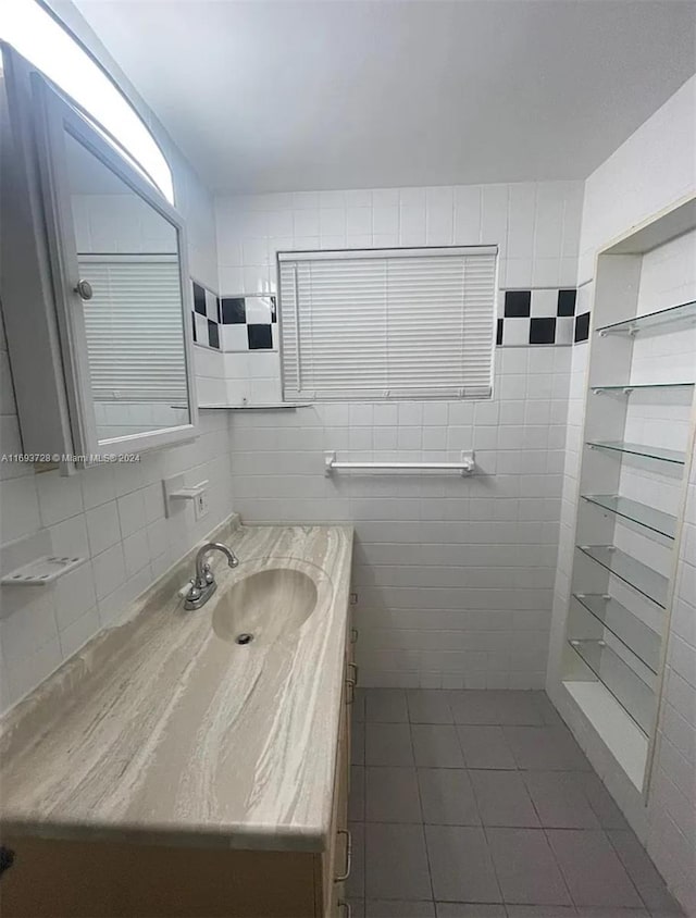 bathroom featuring tile patterned flooring, vanity, and tile walls