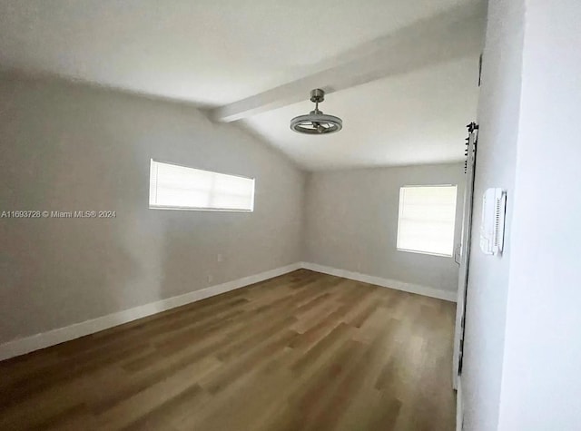 empty room featuring hardwood / wood-style floors and lofted ceiling with beams