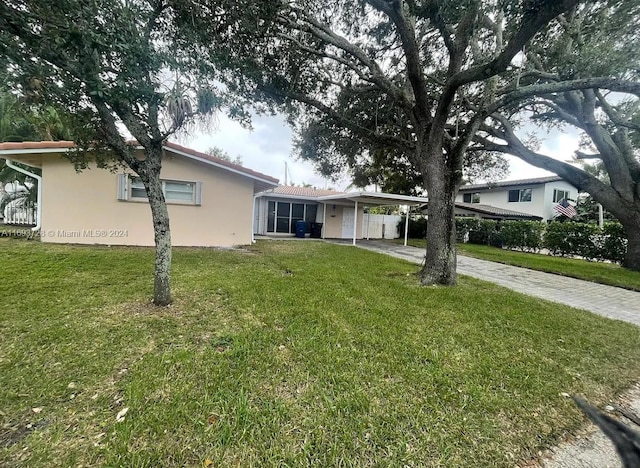 view of front facade with a carport and a front lawn