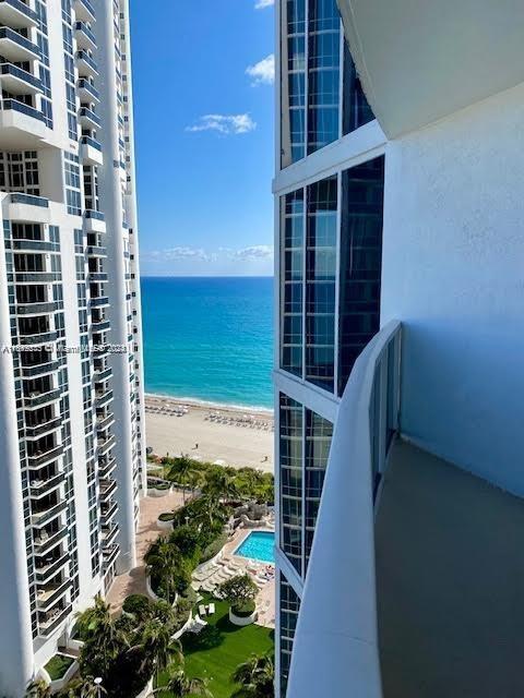 balcony with a water view and a beach view