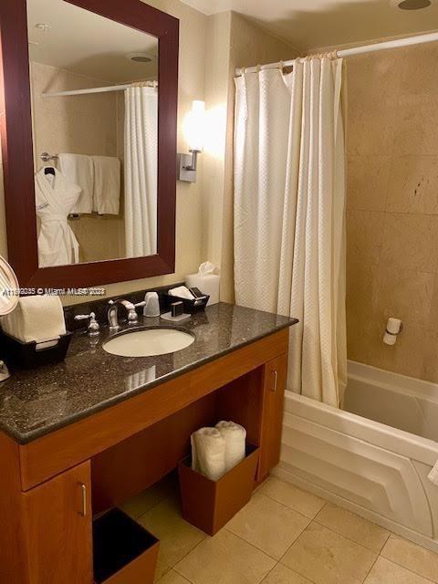 bathroom with tile patterned floors, vanity, and shower / bathtub combination with curtain