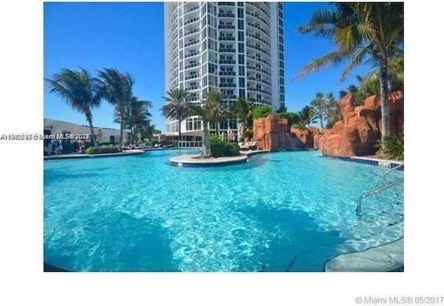 view of swimming pool with pool water feature