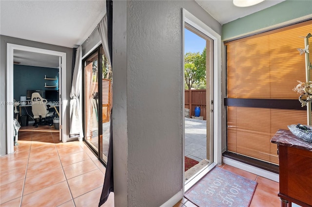 doorway to outside with plenty of natural light and light tile patterned floors