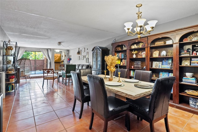 dining room featuring a chandelier, tile patterned floors, and a textured ceiling