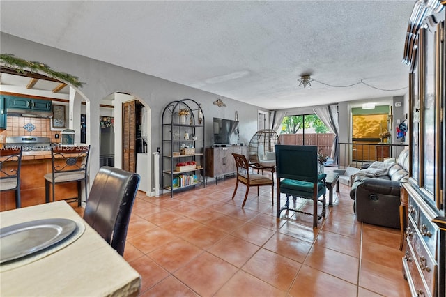 tiled dining room with a textured ceiling