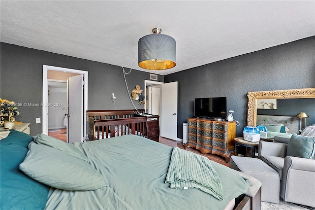 bedroom featuring wood-type flooring and a textured ceiling