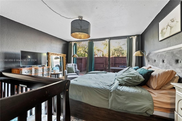 bedroom featuring access to exterior, a textured ceiling, and expansive windows