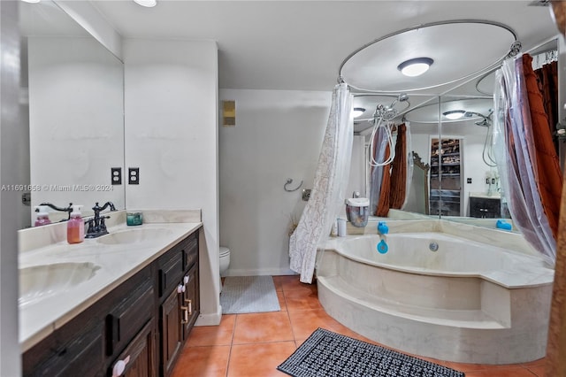 bathroom featuring tile patterned floors, a bathtub, vanity, and toilet