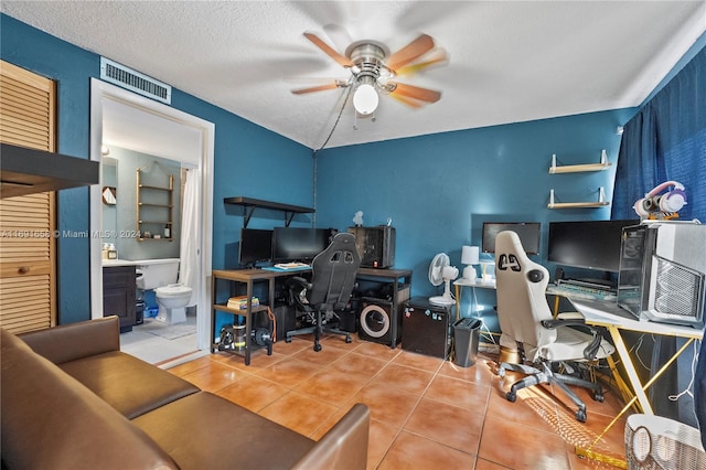 office area with ceiling fan, tile patterned flooring, and a textured ceiling