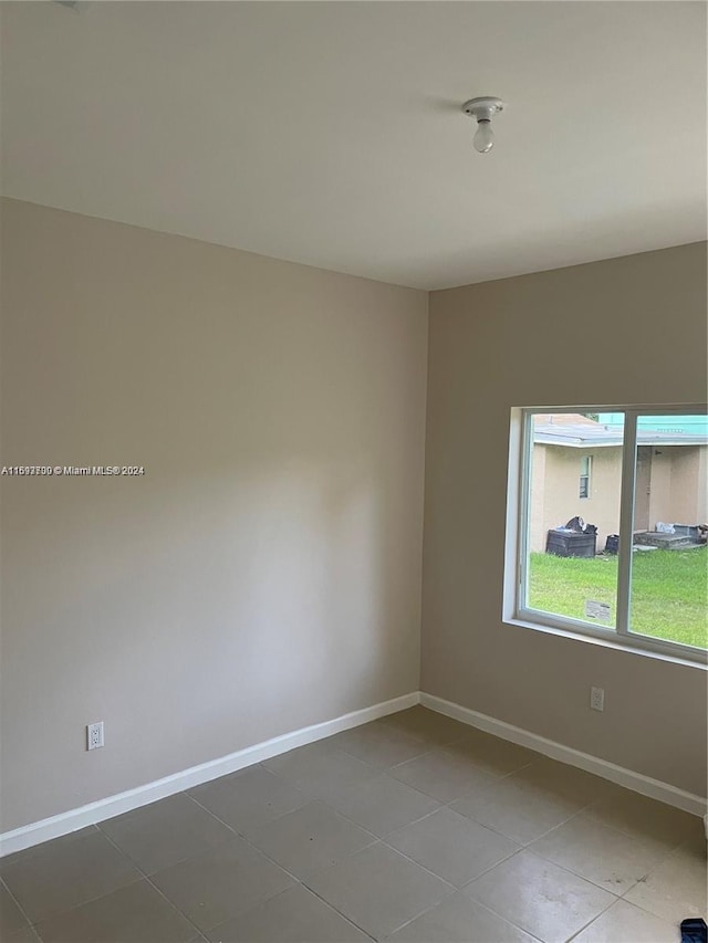 unfurnished room with tile patterned flooring