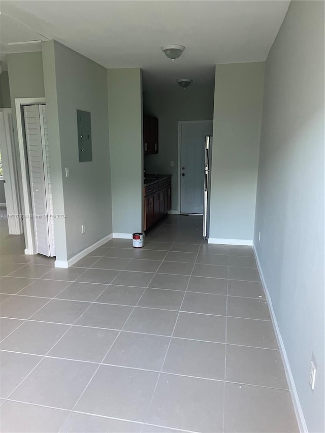 hall with electric panel and light tile patterned flooring