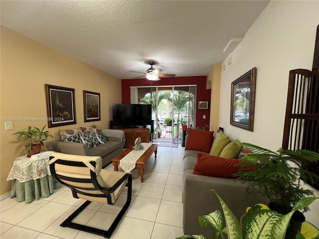 living room with ceiling fan, light tile patterned flooring, and a textured ceiling