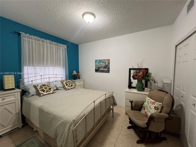 bedroom with light tile patterned floors and a textured ceiling