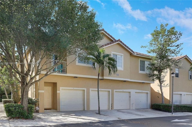 townhome / multi-family property with a balcony and a garage