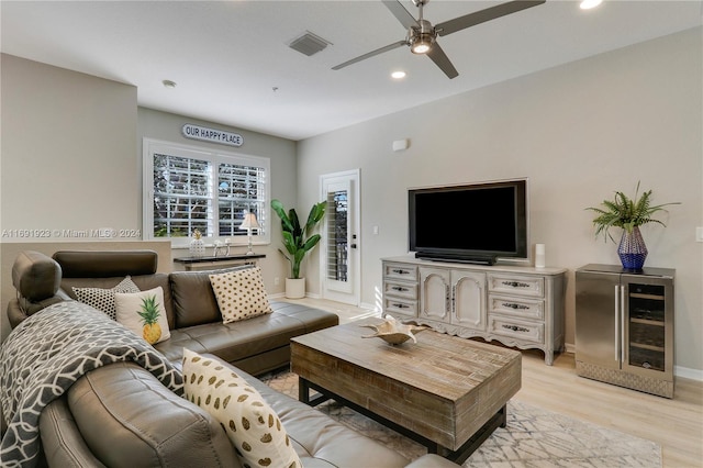 living room featuring wine cooler, ceiling fan, and light hardwood / wood-style floors