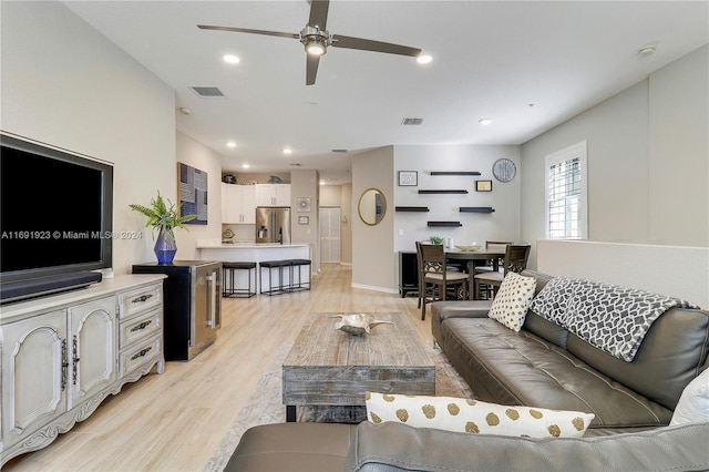 living room featuring light hardwood / wood-style flooring and ceiling fan