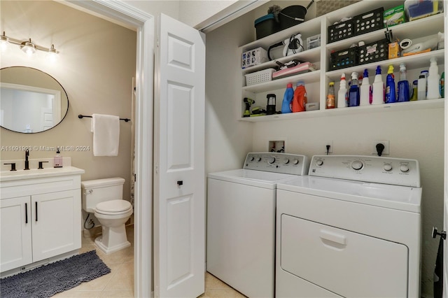 washroom featuring light tile patterned floors, sink, and separate washer and dryer