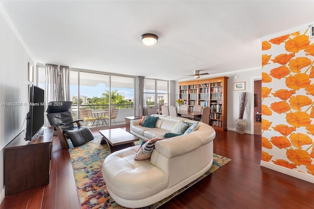 living room featuring ceiling fan, dark hardwood / wood-style flooring, ornamental molding, and a wall of windows