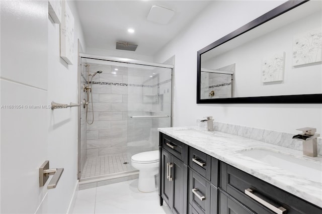 bathroom with vanity, toilet, and a shower with door