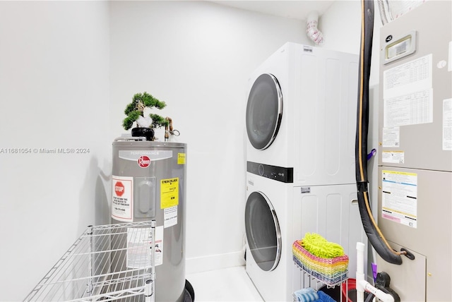 clothes washing area featuring electric water heater and stacked washer and clothes dryer