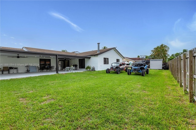 rear view of property with a yard, a patio, and ceiling fan