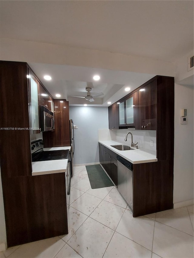 kitchen featuring ceiling fan, sink, dark brown cabinets, light tile patterned floors, and appliances with stainless steel finishes