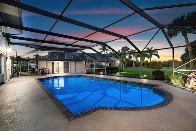 pool at dusk with a patio and a lanai