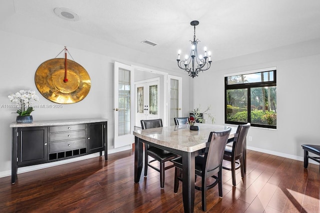 dining room with french doors, an inviting chandelier, and dark wood-type flooring