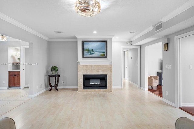 living room featuring crown molding, a fireplace, and light wood-type flooring