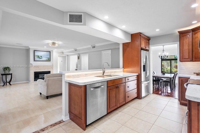 kitchen featuring sink, appliances with stainless steel finishes, ornamental molding, light tile patterned flooring, and a chandelier