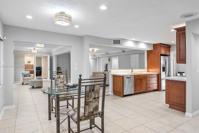 tiled dining room with ornamental molding and sink