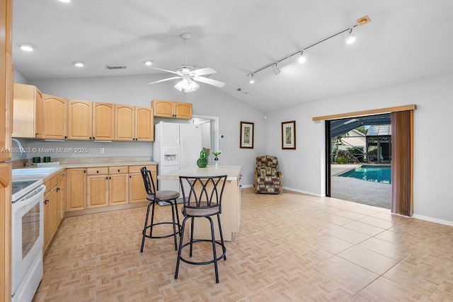 kitchen with lofted ceiling, a kitchen breakfast bar, white fridge with ice dispenser, range, and light brown cabinets