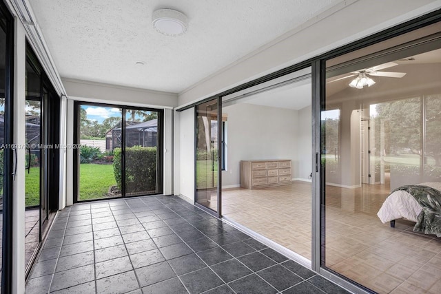 unfurnished sunroom featuring ceiling fan