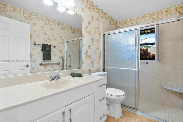 bathroom with parquet floors, vanity, toilet, and a shower with door