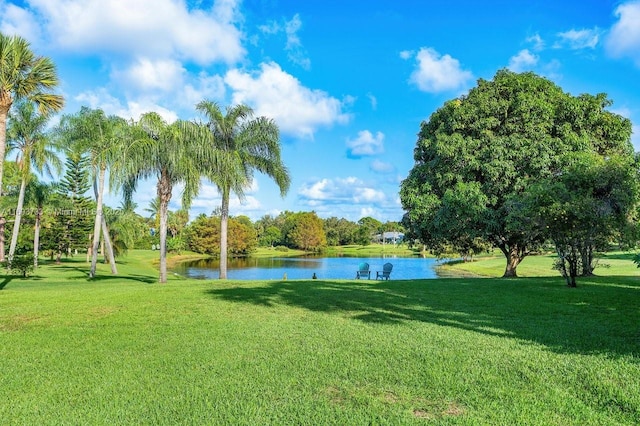 surrounding community featuring a water view and a lawn