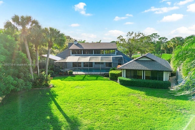 view of yard with a pool, a lanai, and a sunroom